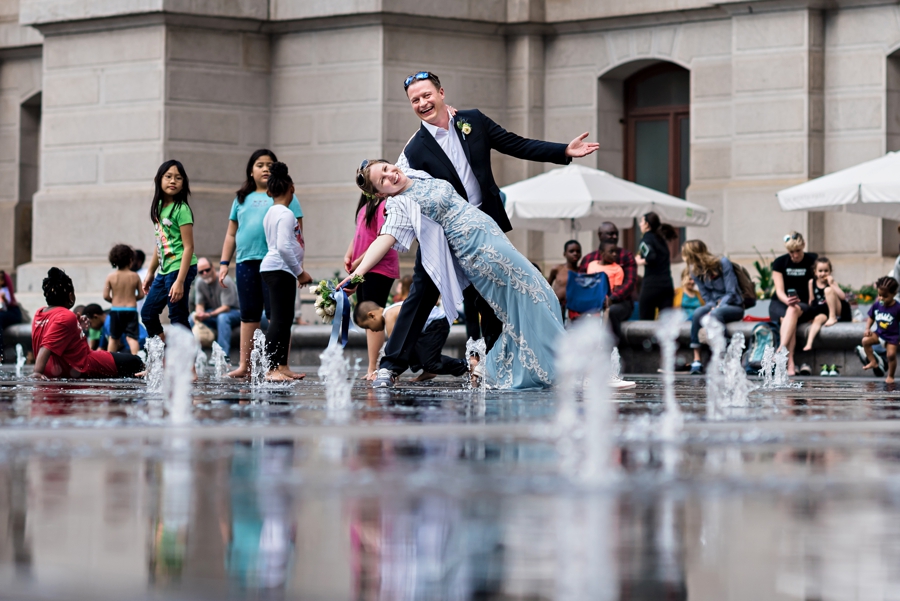 A groom dips his bride in the fountains at Dilworth Park in Philly.